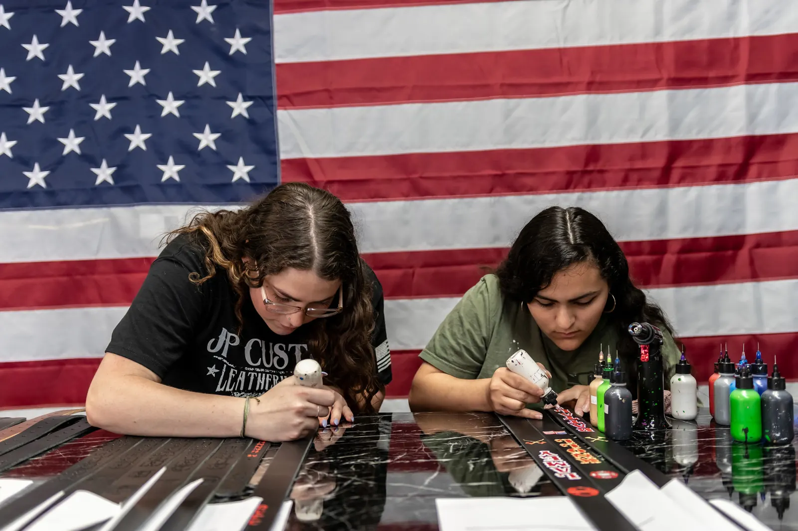 The JP team hand-painting straps beneath the American flag